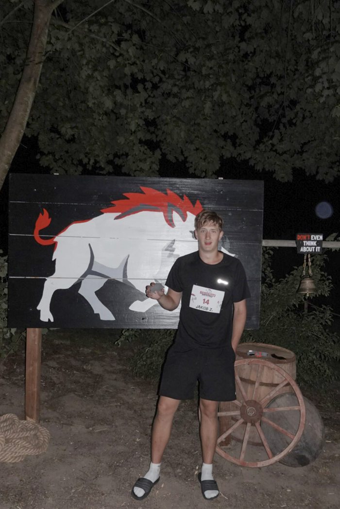 Jakob Ziegelbäck, Assist 2026, im schwarzen Outfit vor der Wildschwein-Wand