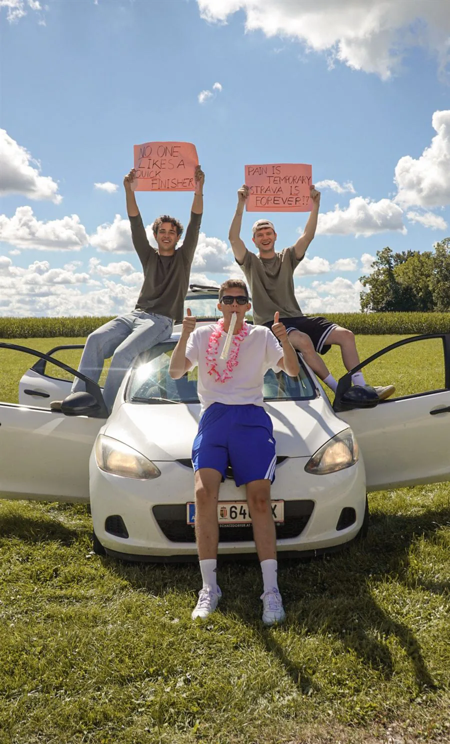 Fans mit Schildern auf dem Auto vor blauem Himmel